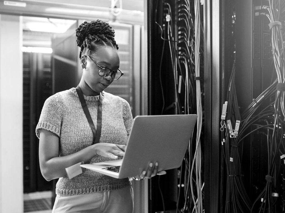IT engineer working on a laptop in a server room