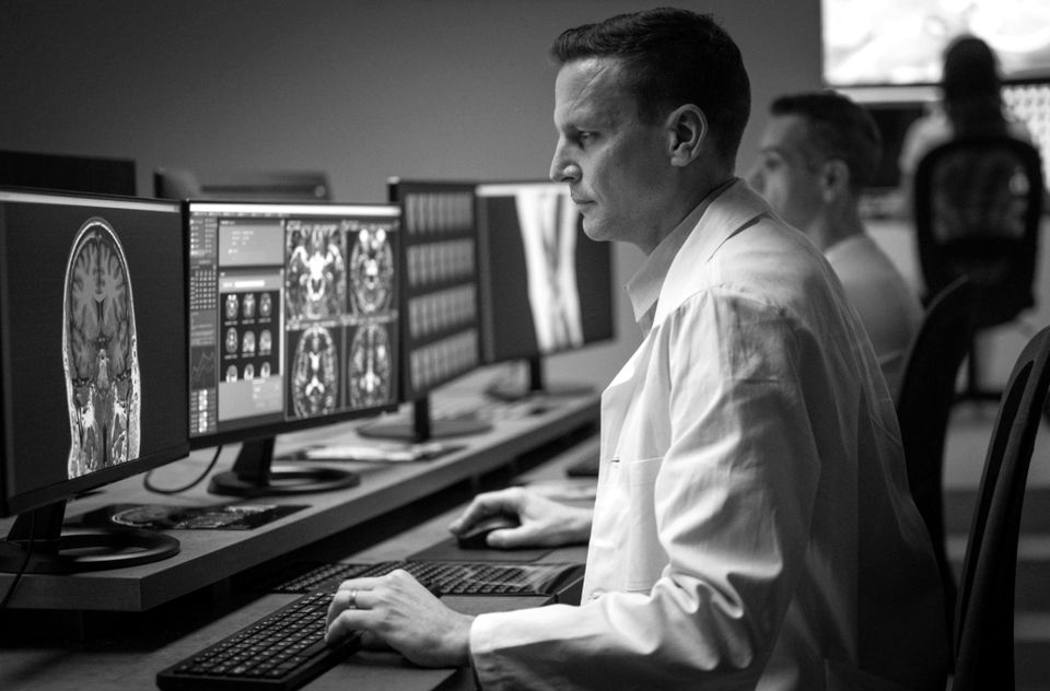 Radiologist reading studies at a multi-monitor workstation